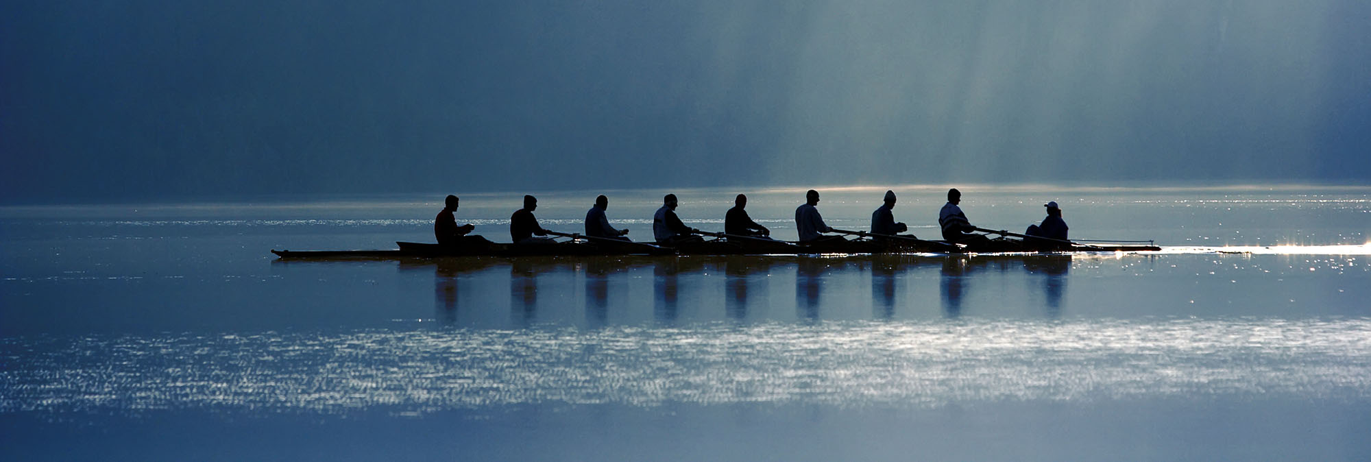 team of people rowing a canoe